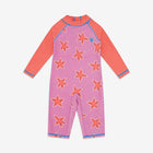 A UV Protective Surf Suit Pink Starfish all-in-one swimsuit. It has long orange sleeves and a lilac torso covered with starfish pattern.